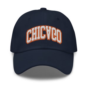 May include: A navy blue baseball cap with an orange and white embroidered "CHICAGO" logo.