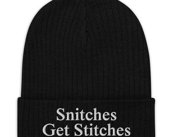 May include: Black knit beanie with the text "Snitches Get Stitches" embroidered in white on the cuff.