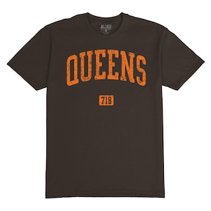 Puede incluir: Una camiseta marrón con un gráfico naranja desgastado que dice "QUEENS" con el número "718" debajo.