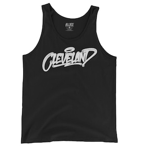 May include: Black tank top with a white graphic of the word "CLEVELAND" in a graffiti style.