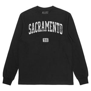 Puede incluir: Camiseta negra de manga larga con un gráfico blanco desgastado que dice "SACRAMENTO" en un arco con "916" debajo. La camiseta tiene cuello redondo y mangas largas.