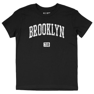 May include: Black t-shirt with a white distressed graphic that says "BROOKLYN" with "718" underneath.