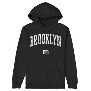 May include: Black hooded sweatshirt with a white distressed graphic that says "BROOKLYN" and "718" underneath.