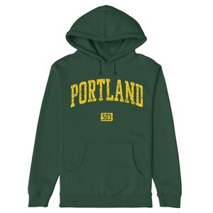 May include: A dark green hooded sweatshirt with a yellow distressed graphic that says "PORTLAND" with the number "503" underneath.