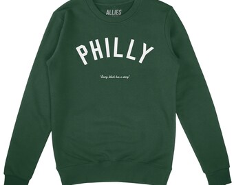 Może przedstawiać: Ciemnozielona bluza z napisem "PHILLY" dużymi białymi literami na piersi. Poniżej znajduje się fraza "Every block has a story" w mniejszym białym tekście. Nazwa marki "ALLIES" jest wydrukowana na górze na biało.