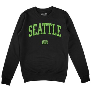 May include: Black sweatshirt with a green graphic print of "SEATTLE 206" in a vintage collegiate style.