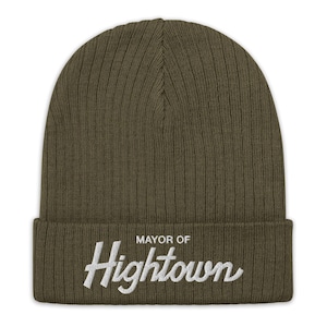 May include: A green knitted beanie with the text "Mayor of Hightown" embroidered in white on the front.