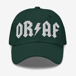 Op de afbeelding: Een donker bosgroene baseballpet met witte geborduurde tekst die OR AF leest, waarbij een bliksemschicht het schuine streepje tussen de letters vervangt. De pet heeft een gestructureerde kroon, een gebogen klep en een knoopje bovenop.
