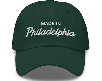May include: A dark green baseball cap with white embroidered text that reads "MADE IN Philadelphia".