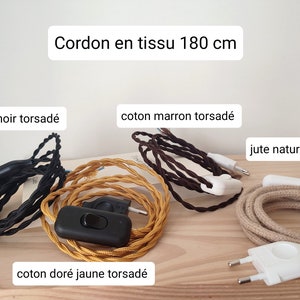 May include: Four 180 cm fabric cords with plugs and switches. The cords include black twisted cotton, brown twisted cotton, gold yellow twisted cotton, and round natural jute. Each cord features a plug and an integrated power switch.