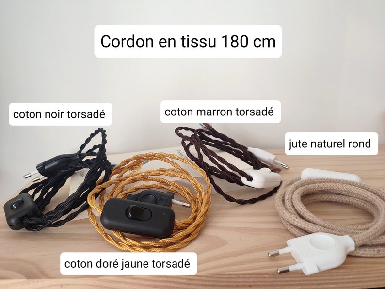May include: Four 180 cm fabric cords with plugs and switches. The cords include black twisted cotton, brown twisted cotton, gold yellow twisted cotton, and round natural jute. Each cord features a plug and an integrated power switch.