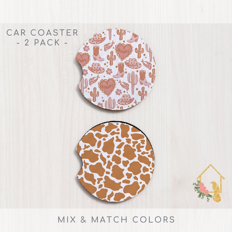May include: Two car coasters, one with a pink and white pattern of cacti, boots, hats, and hearts with the word "Howdy" on the hearts, and the other with a brown and white cow print pattern.