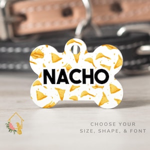 May include: White bone-shaped dog tag with a gold and white pattern of tortilla chips and the word "NACHO" in black text.