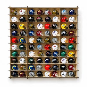 Può includere: Un grande espositore da parete in legno con una griglia di sessanta scomparti individuali. Ogni vano contiene un casco da football in miniatura, che rappresenta diverse squadre professionistiche con colori, loghi e maschere distintivi.