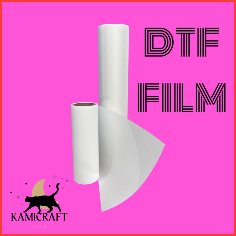 Puede incluir: Rollos de pel&iacute;cula DTF blancos sobre un fondo rosa brillante. La imagen presenta dos rollos de pel&iacute;cula, uno grande y otro m&aacute;s peque&ntilde;o, con una hoja parcialmente desenrollada. El texto "DTF FILM" se muestra en negro, junto con un logotipo.