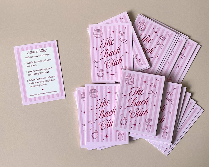 Pode incluir: Um conjunto de cart&otilde;es rosa e branco listrados com o texto "The Bach Club" em it&aacute;lico. Os cart&otilde;es apresentam ilustra&ccedil;&otilde;es de uma bola de discoteca, um anel, uma c&acirc;mera e uma cadeira. Um cart&atilde;o menor com instru&ccedil;&otilde;es tamb&eacute;m est&aacute; presente.