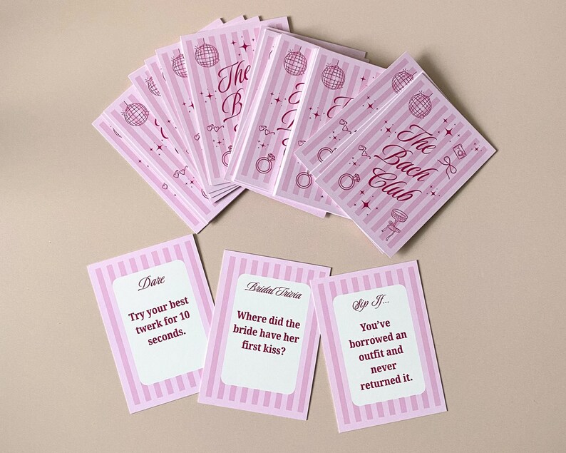 Pode incluir: Cart&otilde;es listrados em rosa e branco com o texto "The Bach Club" e ilustra&ccedil;&otilde;es tem&aacute;ticas de casamento. Tr&ecirc;s cart&otilde;es individuais com perguntas e desafios tamb&eacute;m s&atilde;o vis&iacute;veis. Ideal para uma despedida de solteira.