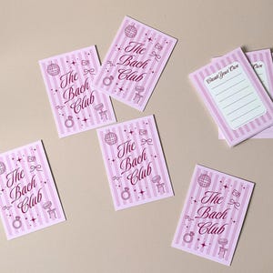 Pode incluir: Cart&otilde;es listrados em rosa e branco com o texto "The Bach Club" e v&aacute;rias ilustra&ccedil;&otilde;es. Uma pilha de cart&otilde;es com o texto "Create Your Own" tamb&eacute;m &eacute; vis&iacute;vel.