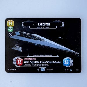 Puede incluir: Una carta de juego de mesa en blanco y negro con una nave espacial con el texto "EXECUTOR" y "MIGHT OF THE EMPIRE". La carta también tiene el texto "When Played/On Attack/When Defeated: Create 3 TIE Fighter tokens."