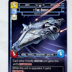 May include: A trading card featuring a spaceship illustration labeled "The Ghost" with the text "Heart of the Family." The card has a blue and gray color scheme with the number 5 in a yellow box and the number 6 in a blue box.