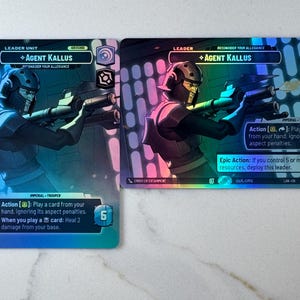 May include: Two trading cards featuring Agent Kallus, a character from a science fiction franchise. The cards have a holographic sheen and feature the character in a combat pose, holding a blaster. Text on the cards includes game actions and character details.