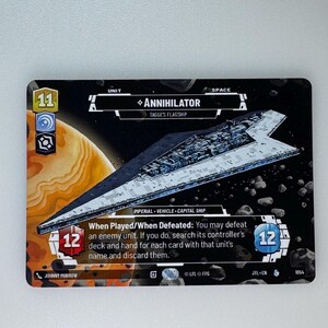 May include: A black and white card with a blue and gray spaceship on it. The card is from the Star Wars: Destiny trading card game. The card is titled "Annihilator" and is a unit with a cost of 11. The card has a power of 12 and a health of 12. The card text reads "When Played/When Defeated: You may defeat an enemy unit. If you do, search its controller's deck and hand for each card with that unit's name and discard them."