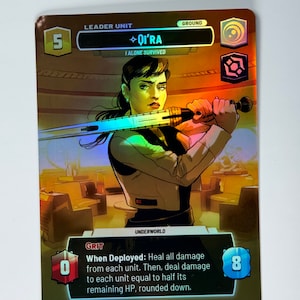 Puede incluir: Una carta holográfica de Star Wars: Destiny con Qi'ra, un personaje femenino con cabello castaño y una camisa blanca, sosteniendo un sable de luz. El texto de la carta dice "Cuando se despliega: Cura todo el daño de cada unidad. Luego, inflige daño a cada unidad igual a la mitad de su HP restante, redondeado hacia abajo."