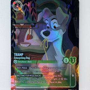 May include: A collectible card game card featuring Tramp, a character from Disney's Lady and the Tramp. The card is holographic and features a colourful background. The card text reads "TRAMP, Enterprising Dog, Storyborn. Hero, HEY, PIDGE If you have a character named Lady in play, you pay 1 less to play this character. NO TIME FOR WISECRACKS When you play this character, chosen character of yours gets +1 this turn for each other character you have in play."