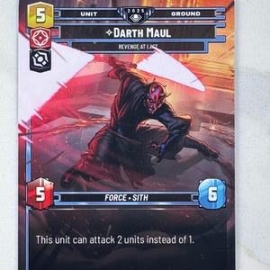 May include: A trading card featuring Darth Maul from the Star Wars universe. The card has a red and black color scheme, with the character in action. Text includes "Darth Maul", "Revenge at Last", and game stats.