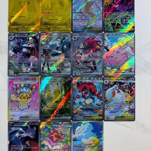 May include: A collection of fourteen rectangular trading cards arranged in a grid. Each card features colorful illustrations of various creatures, holographic foil details, printed text, and numerical values indicating power levels.