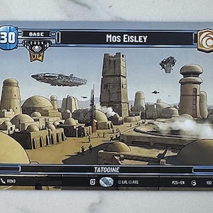May include: A trading card featuring a desert city scene with the text "Mos Eisley" and "Tatooine." The card has a blue and white border with a number 30 in the upper left corner. Several flying vehicles are in the sky.