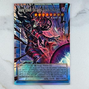 Puede incluir: Una carta coleccionable con el personaje "Black Chaos the Dark Chaos Magician". La carta tiene un esquema de color oscuro con una ilustraci&oacute;n detallada de una figura en una pose din&aacute;mica. El texto de la carta incluye el nombre, los atributos y los efectos del personaje.