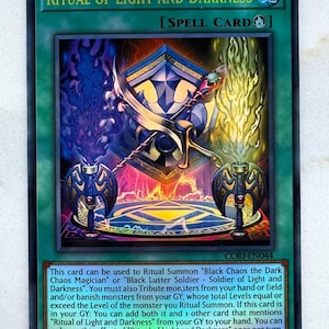 May include: A Yu-Gi-Oh! trading card titled "Ritual of Light and Darkness." The card features a detailed illustration with a central shield design, a sword, and flames. The card's text describes its use in Ritual Summoning.