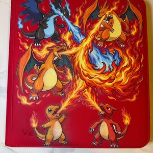 Può includere: Raccoglitore rosso per carte collezionabili con una vivace illustrazione di vari personaggi di draghi di tipo fuoco. L'opera raffigura draghi che sputano fuoco e fiamme in tonalità arancioni, gialle e blu. Il raccoglitore ha il testo "VA" in basso a sinistra.