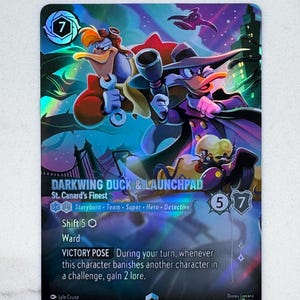 Könnte beinhalten: Eine holografische Disney Lorcana Sammelkarte mit Darkwing Duck und Launchpad McQuack. Die Karte zeigt den Titel Darkwing Duck & Launchpad, St. Canard's Finest, Spielstatistiken, die Fähigkeit Victory Pose und eine lebendige, dunkel gehaltene Illustration der Charaktere vor einer nächtlichen Stadtkulisse.