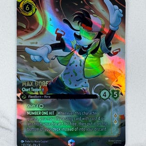 May include: A holographic trading card featuring Max Goofy from Disney's Lorcana. The card has a green and yellow color scheme, with Max wearing a green jacket and sunglasses. Text includes "MAX GOOFY Chart Topper" and "NUMBER ONE HIT".