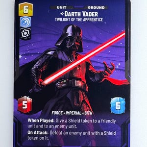 Może przedstawiać: Karta kolekcjonerska Star Wars z Darthem Vaderem z "Twilight of the Apprentice". Karta przedstawia Dartha Vadera z czerwonym mieczem świetlnym na ciemnofioletowym tle. Tekst gry i liczby 6, 5 i 6.