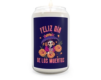 May include: A white candle in a glass jar with a blue label. The label features a colorful illustration of a skeleton wearing a purple hat and holding marigolds. The text on the label reads "Feliz Dia de los Muertos".