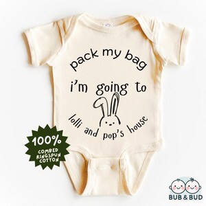 Puede incluir: Un body de bebé de color crema con mangas cortas y un gráfico negro que dice "pack my bag i'm going to lolli and pop's house". El body está hecho de 100% algodón peinado ringspun.