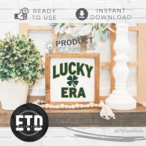 Op de afbeelding: Een houten bord met de woorden "LUCKY ERA" in groene letters en een groene klaver. Het bord wordt tentoongesteld op een houten plank met decoratieve elementen, waaronder een witte pilaar en een plant in een pot.