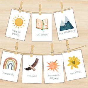 May include: Eight white cards with watercolour illustrations and positive affirmations. The cards include a sun, a book, mountains, a rainbow, a bird, a star, a flower, and the following text: "Today is a good day", "I love to learn", "I can do hard things", "I am VALUED", "I will SOAR", "I can make a difference", "I am JOYFUL".