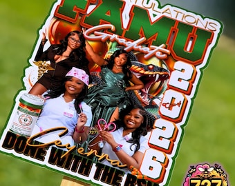 May include: A graduation yard sign featuring the text "Congratulations FAMU Graduates 2026" with images of graduates. The sign includes the text "Done with the BSN" and a logo with a bee.