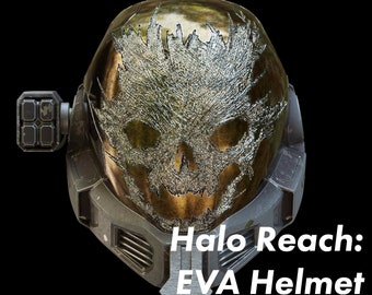 Może przedstawiać: Złoty i srebrny hełm Halo Reach EVA z wzorem czaszki na wizjerze.