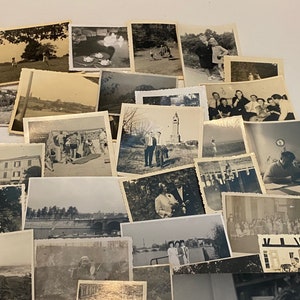 May include: A collection of vintage black and white photographs, arranged in a layered display. The images depict various scenes, including landscapes, people, and buildings. The photographs have a classic, nostalgic aesthetic, with visible signs of age and wear.