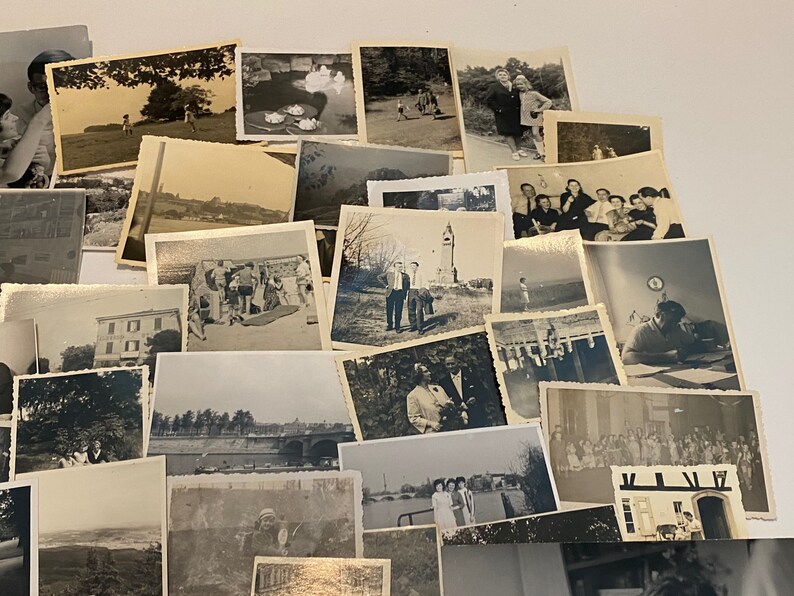 May include: A collection of vintage black and white photographs, arranged in a layered display. The images depict various scenes, including landscapes, people, and buildings. The photographs have a classic, nostalgic aesthetic, with visible signs of age and wear.