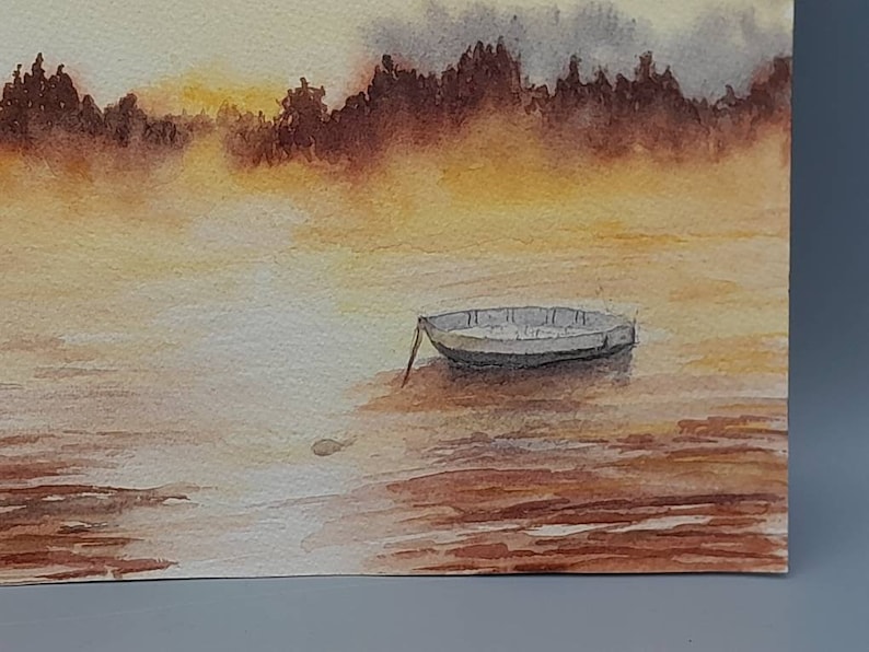 May include: A watercolor painting of a small boat on a lake with a misty background. The water is a light brown color and the boat is a light gray color. The background is a light yellow color with a hint of orange.