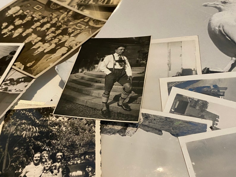 K&ouml;nnte beinhalten: Eine Sammlung von alten Schwarzwei&szlig;fotos, einige mit Personen, andere mit Landschaften und eines mit einem Vogel. Die Fotos sind auf einer wei&szlig;en Oberfl&auml;che angeordnet.