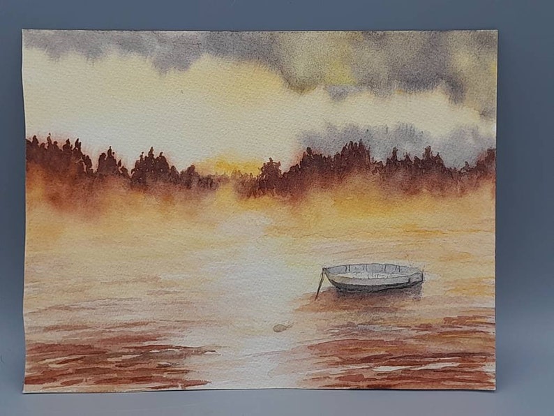 May include: Watercolor painting of a small boat on a lake with a foggy, golden sunset in the background. The trees on the shore are silhouetted against the sky.