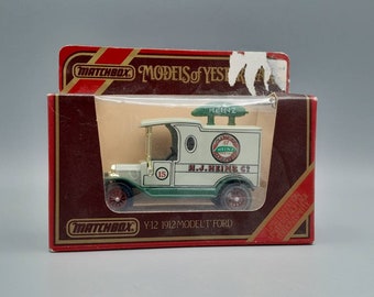 Puede incluir: Un camión de juguete Matchbox Y-12 1912 Model T Ford en su caja original. El camión es blanco y verde con el logotipo y el texto de Heinz. La caja es roja y marrón con el logotipo de Matchbox y el texto "Models of Yesteryear".