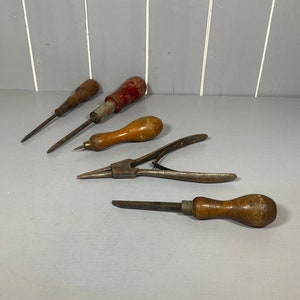 May include: A set of four vintage tools with wooden handles. The tools include two screwdrivers, a pair of pliers, and a chisel.